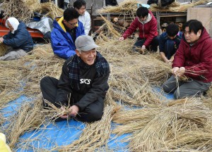 Local villagers make straw costumes in the morning of the festival day.