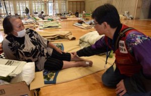 A doctor sent by Kagoshima Prefectural Welfare Federation of Agricultural Cooperatives is advising one of the evacuated people on how to avoid economy class syndrome due to a long stay at the public shelter. (Uto-shi, Kumamoto prefecture)