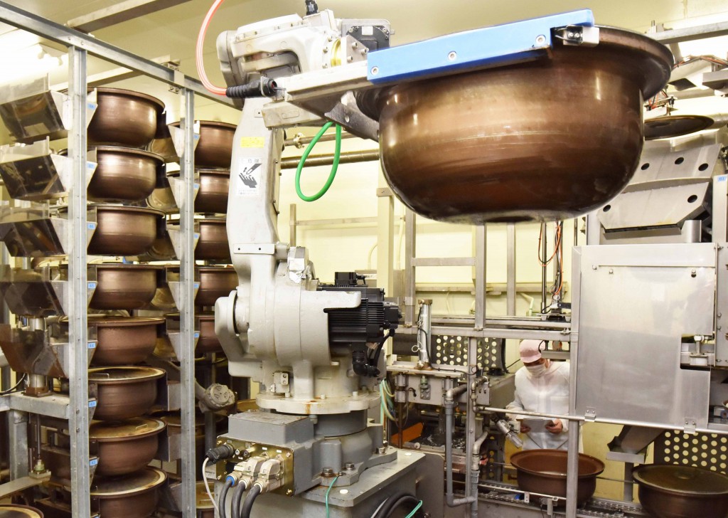 Rice is cooked using fully automated cookers at a company in Yokohama.