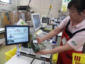 When a QR code of a farm product is read at the cash counter, a portrait photograph of its producer comes on the monitor screen for customers. (JA Chichibu’s farmer’s market at Road Station Minano, Minano-machi, Saitama prefecture)