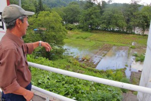 A farmer points at a flooded potato field in the Shimokanayama district in Minamifurano, Hokkaido, on Wednesday, Aug. 31.
