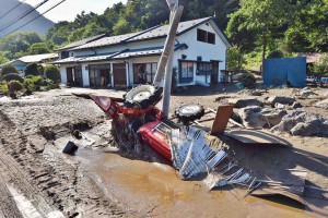  A tractor is buried on its side in muddy water on a road shoulder in the town of Iwaizumi, Iwate Prefecture, on Wednesday, Aug. 31, after the area was flooded due to heavy rain.