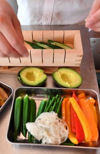 Colorful vegetable cuts are placed in a wooden mold to make vegesushi in Narashino, Chiba Prefecture.