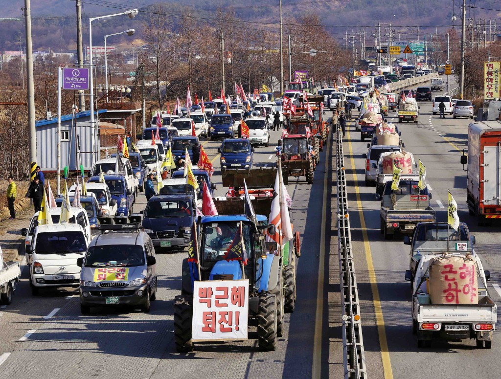 Rows of tractors hanging up placards and flags with such messages as “Park Guen-hye, step down” and “Guarantee stable rice price” are seen in Anseong city, Gyeonggi-do, on Nov. 25.