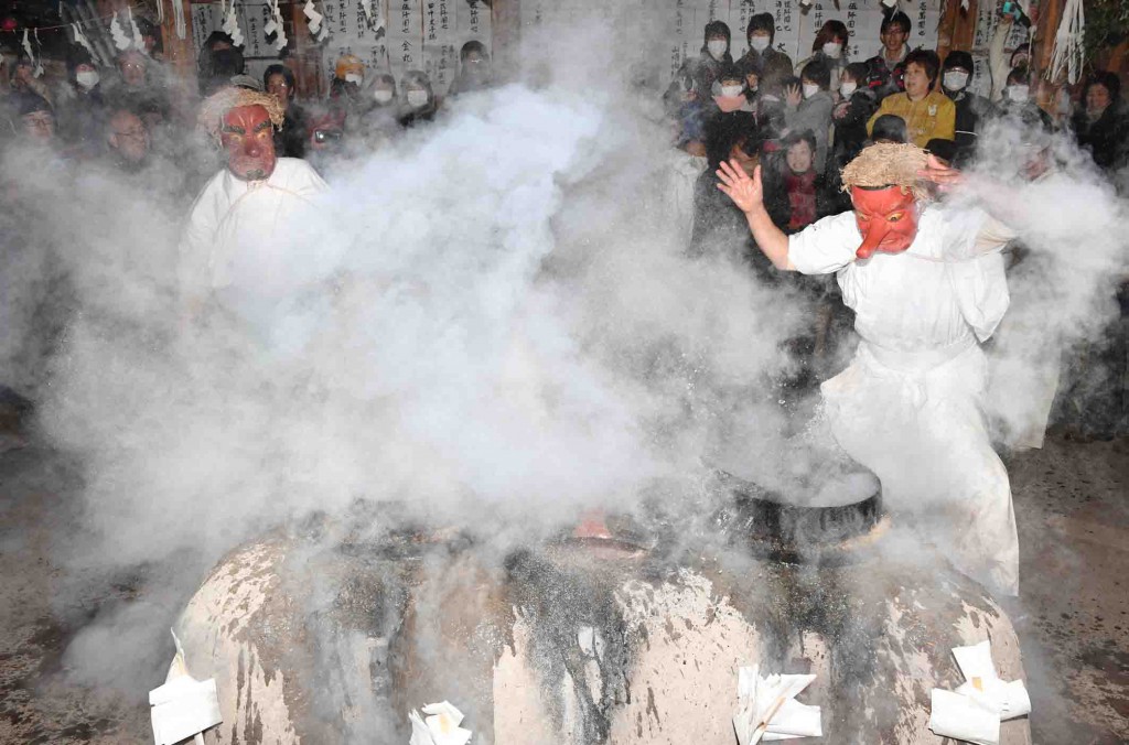 Villagers dressed as the Mizuno-o (right) and Tsuchino-o gods with “tengu” (long-nosed goblin) masks present the “yukiri,” a performance of splashing boiling water barehanded, in the Shimotsuki Matsuri festival in Iida, Nagano Prefecture.