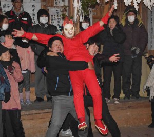 A villager portraying the Inari god with a fox mask dives into a crowd of audience amid calls from the people.