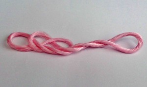 The “red silk of fate” is made by twisting together two kinds of silk threads, one containing oxytocin and the other containing red pigment.(Courtesy of National Agriculture and Food Research Organization)