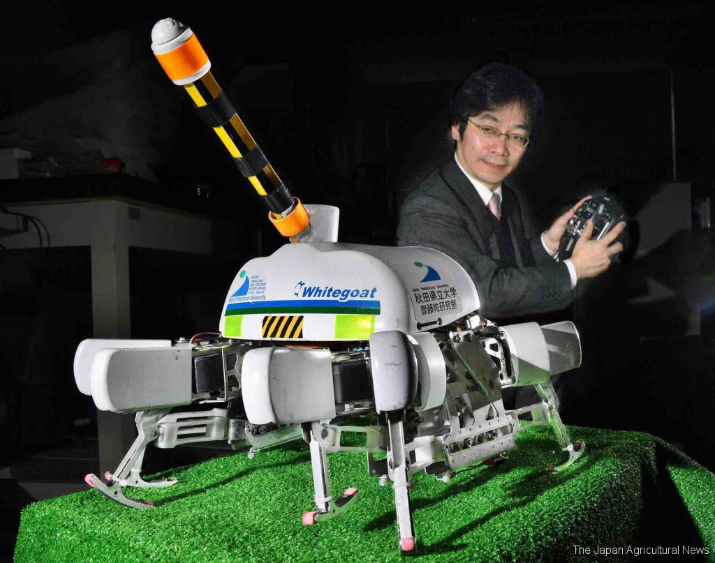 Takashi Saito controls one of prototype scarecrow robots about the size of a puppy in Yurihonjo, Akita Prefecture.