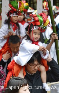 Children entering the shrine with rice seedlings in hand. They hand seedlings to Saotome Teshiro.