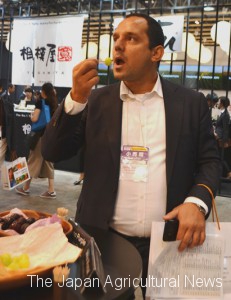 A British buyer eats a Shine Muscat grape at “Japan’s Food” export fair in the city of Chiba.