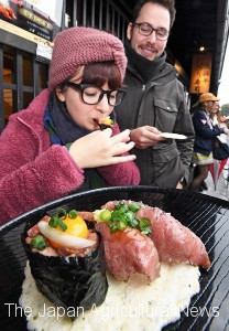 A Mexican tourist tastes wagyu sushi in Takayama, Gifu Prefecture.