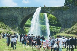 Gallons of water are released from the sides of Tsujun Bridge in Yamato, Kumamoto Prefecture, newly designated as a national treasure.