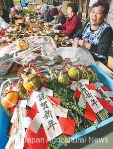 Ito (right) making shimekazari ornament using local materials such as rice straws and hiba tree leaves (in Kami Town, Miyagi Prefecture).