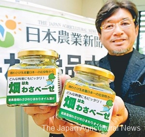 Mitsuru Yaku, head of the judging panel for a local specialty contest, holds Hatawasabeze, which won the grand prize, at The Japan Agricultural News headquarters in Tokyo’s Akihabara district.