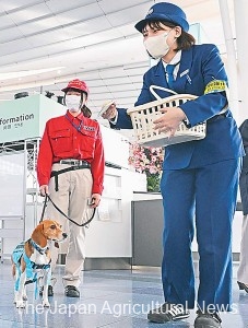 An officer hands out pocket tissues with flyers on animal and plant quarantine promotion campaign at Tokyo’s Haneda Airport.