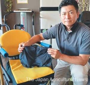 Keisuke Sekiguchi, representative of HAPPINESS KEY, shows a user-friendly wheelchair and cushion in Ota, Gunma Prefecture.