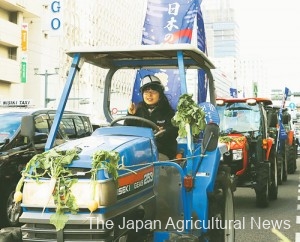 Farmers drive tractors down the street in the city of Hiroshima, heading to the Hiroshima Atomic Bomb Dome during a rally.
